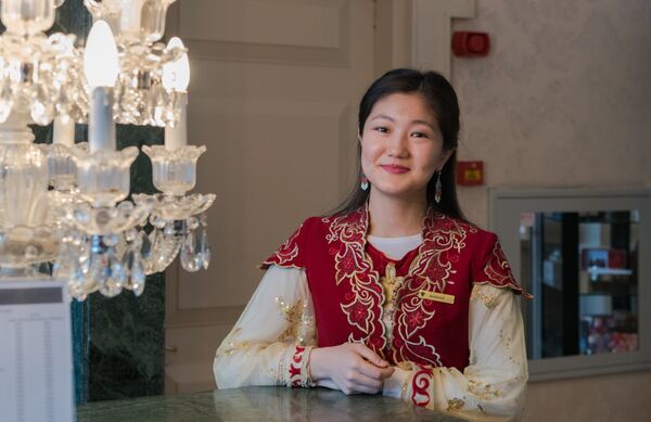 Приветливая девушка  в национальном костюме за стойкой ресепшен отеля Rixos President Astana - Sputnik Казахстан