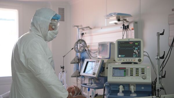 Врач работает с аппаратурой в отделении интенсивной терапии в больнице с коронавирусом в Нур-Султане - Sputnik Қазақстан