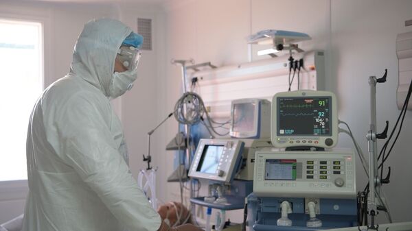 Врач работает с аппаратурой в отделении интенсивной терапии в больнице с коронавирусом в Нур-Султане - Sputnik Казахстан