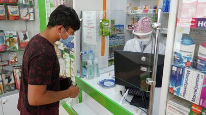 Мужчина покупает лекарства в аптеке, архивное фото