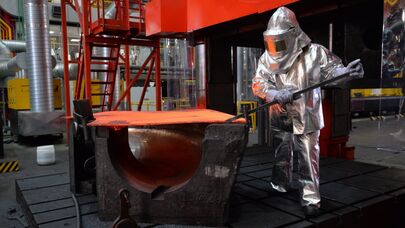 Архивное фото рабочего , устанавливающего заготовку для изделия в пресс на заводе