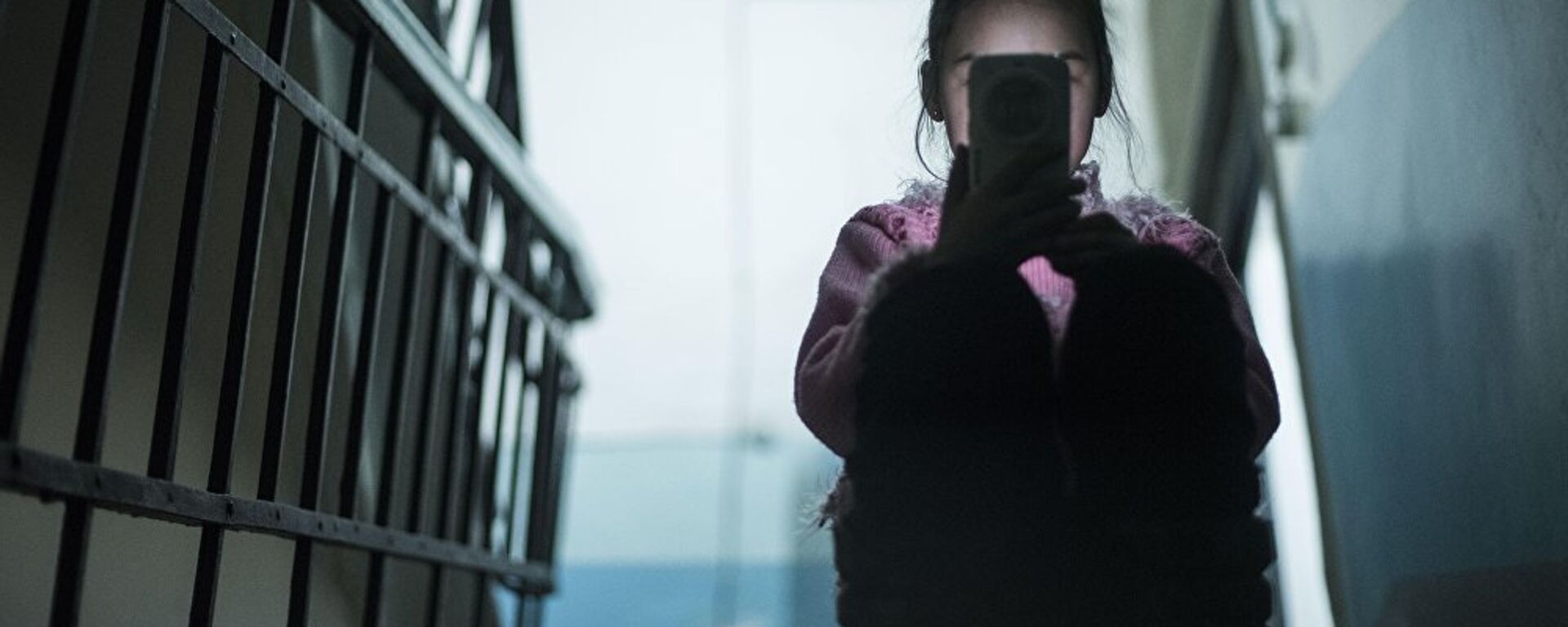 Девочка с мобильным телефоном в руках сидит на лестничной площадке - Sputnik Казахстан, 1920, 16.02.2024