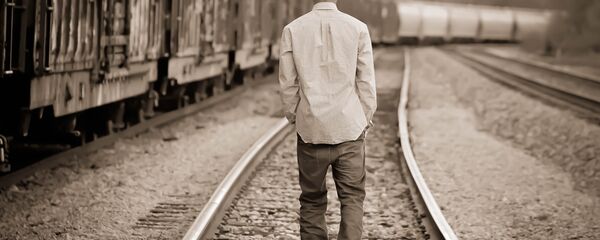 Мужчина шагает по железнодорожным путям - Sputnik Казахстан