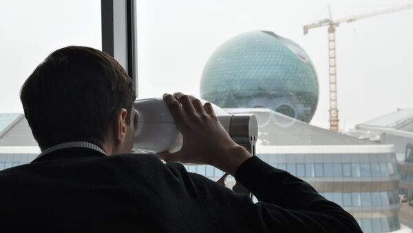 Человек смотрит через специальный оптический прибор на здание главного павильона ЭКСПО-2017 в Астане - Sputnik Казахстан