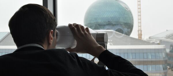 Человек смотрит через специальный оптический прибор на здание главного павильона ЭКСПО-2017 в Астане Человек смотрит через специальный оптический прибор на здание главного павильона ЭКСПО-2017 в Астане - Sputnik Казахстан