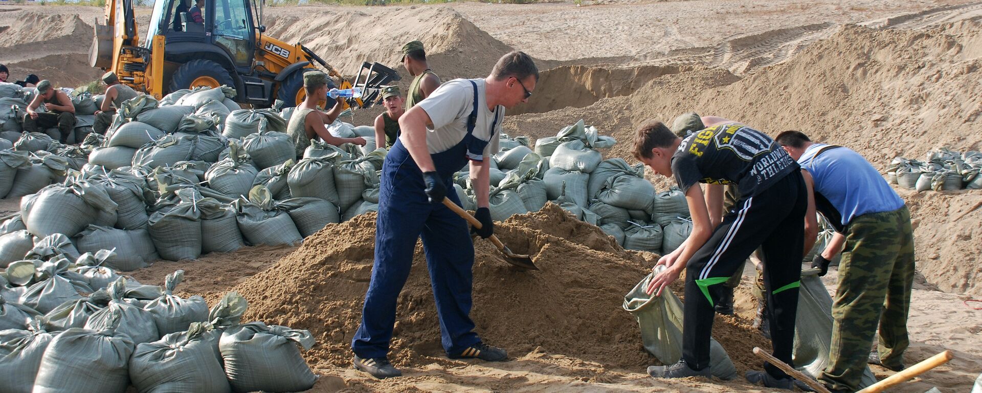 Волонтеры наполняют мешки песком для укрепления дамбы, архивное фото - Sputnik Казахстан, 1920, 30.04.2024
