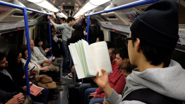 Молодой человек читает книгу в метро - Sputnik Казахстан