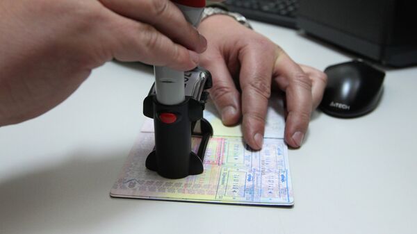 Сотрудник пограничной службы ставит штамп о пересечении границы. Архивное фото - Sputnik Казахстан