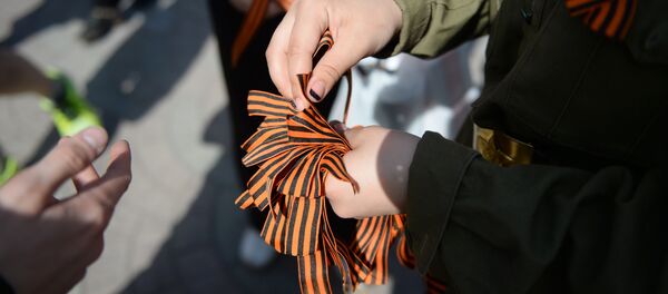 Волонтер раздает георгиевские ленточки, архивное фото Волонтер раздает георгиевские ленточки, архивное фото - Sputnik Казахстан