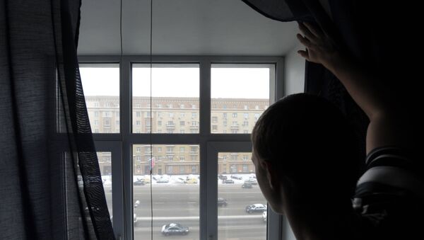 Мужчина смотрит из окна на улицу - Sputnik Казахстан