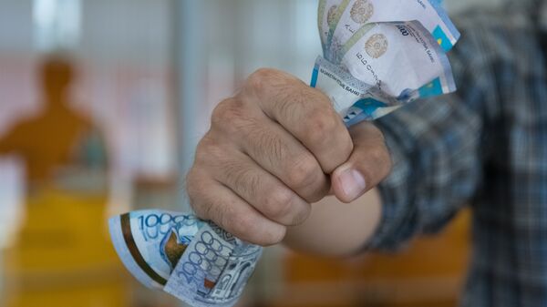 Деньги в кулаке, архивное фото - Sputnik Казахстан