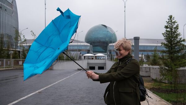 Девушка с зонтом в ветренную погоду на фоне главного павильона ЭКСПО-2017 в Астане - Sputnik Казахстан
