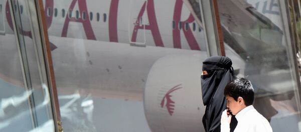 Женщина и мальчик идут мимо офиса Qatar Airways в столице Саудовской Аравии Эр - Рияде, архивное фото Женщина и мальчик идут мимо офиса Qatar Airways в столице Саудовской Аравии Эр - Рияде, архивное фото - Sputnik Казахстан