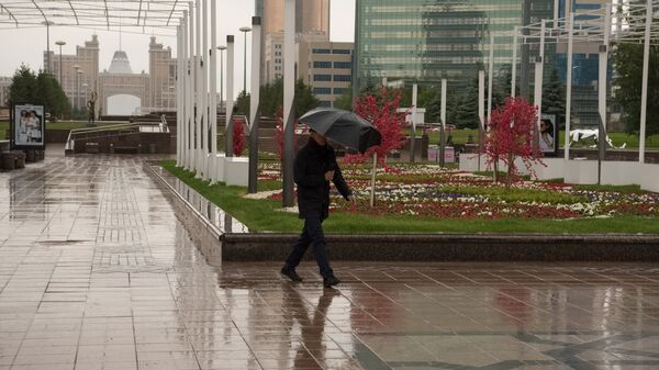Мужчина под зонтом во время дождя - Sputnik Казахстан