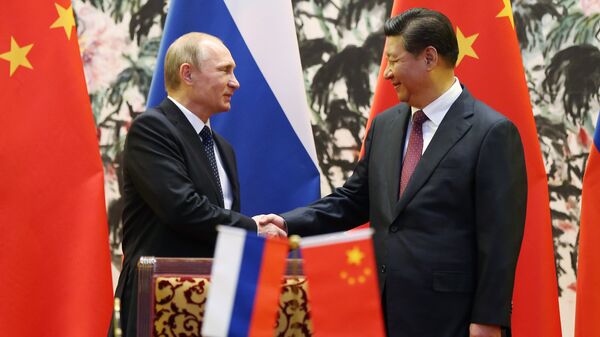 Президент России Владимир Путин (слева) и его китайский коллега Си Цзиньпин пожимают друг другу руки, архивное фото - Sputnik Казахстан