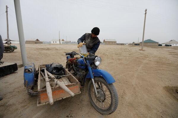Рыбак заправляет свой мотоцикл в деревне вблизи Аральского моря, архивное фото - Sputnik Казахстан