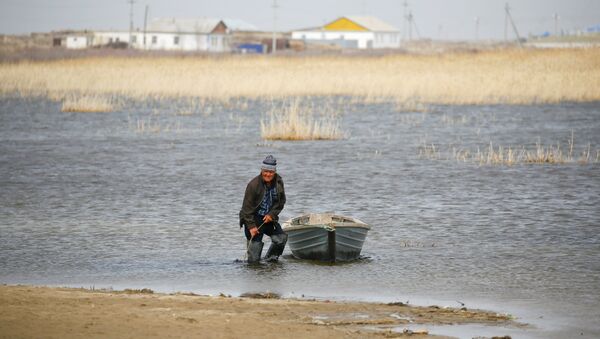 Сельский житель привязывает лодку на берегу Аральского моря, архивное фото - Sputnik Казахстан