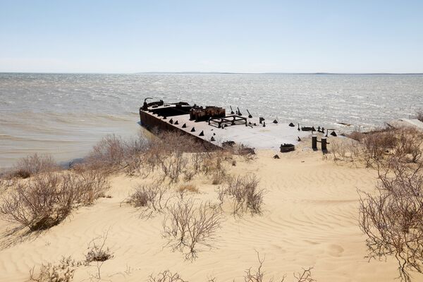 Заброшенное судно лежит между береговой линией Аральского моря и песчаными дюнами, архивное фото Заброшенное судно лежит между береговой линией Аральского моря и песчаными дюнами, архивное фото - Sputnik Казахстан
