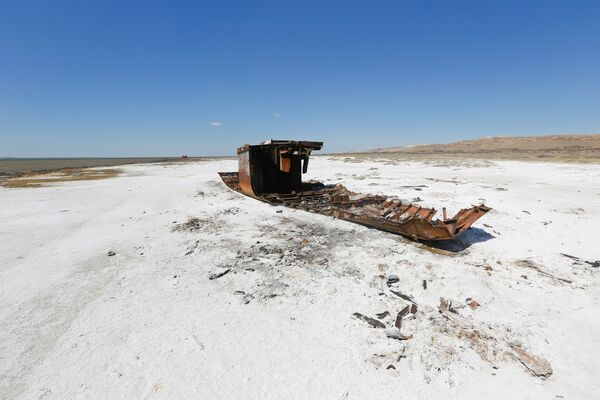 Разрушенный корабль лежит на засоленной части Аральского побережья моря недалеко от местного поселка - Sputnik Казахстан
