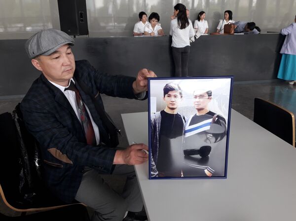 Серик Бегланов демонстрирует фото погибшего сына Серик Бегланов демонстрирует фото погибшего сына - Sputnik Казахстан