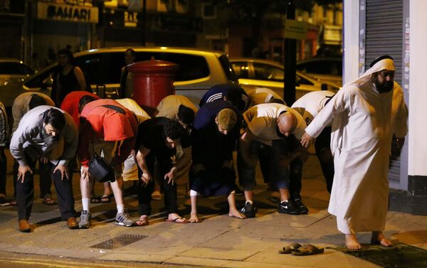 Мужчины молятся после наезда фургона на людей в Лондоне - Sputnik Казахстан