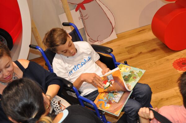 Исаак Мустопуло с книгой сказок Исаак Мустопуло с книгой сказок - Sputnik Казахстан