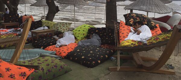 Люди спят на пляже, проведя ночь на свежем воздухе после землетрясения в Битез, курортном городе, расположенном примерно в 6 км к западу от Бодрума, Турция, в пятницу, 21 июля 2017 года - Sputnik Казахстан