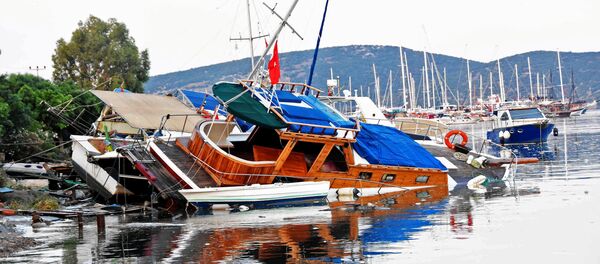 Поврежденные лодки после землетрясения и цунами в курортном городе Гюмбет в провинции Турции Поврежденные лодки после землетрясения и цунами в курортном городе Гюмбет в провинции Турции - Sputnik Казахстан