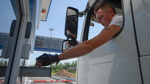 Водитель оплачивает проезд на контрольно-пропускном пункте на платном участке автомобильной дороги, архивное фото - Sputnik Казахстан