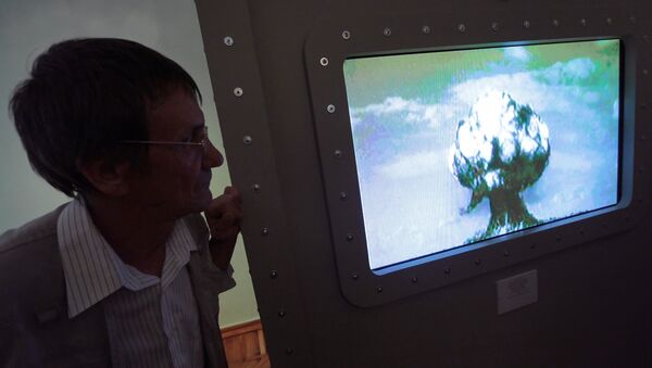Женщина смотрит архивное видео ядерного взрыва - Sputnik Казахстан