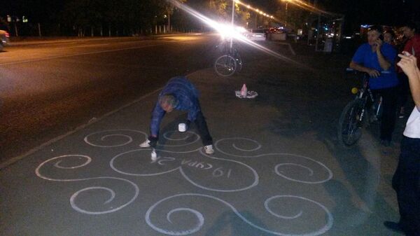 Ер адам асфальтқа сурет салып жатыр Ер адам асфальтқа сурет салып жатыр - Sputnik Қазақстан