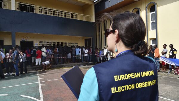 Наблюдатель за выборами в Европейском союзе находится около людей, которые находятся на избирательном участке, архивное фото - Sputnik Казахстан