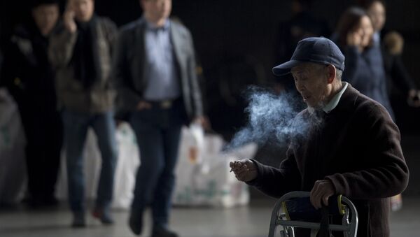 Мужчина курит на железнодорожной станции в Шанхае, архивное фото - Sputnik Казахстан