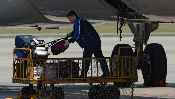 Рабочий разгружает багаж из самолета, архивное фото - Sputnik Казахстан