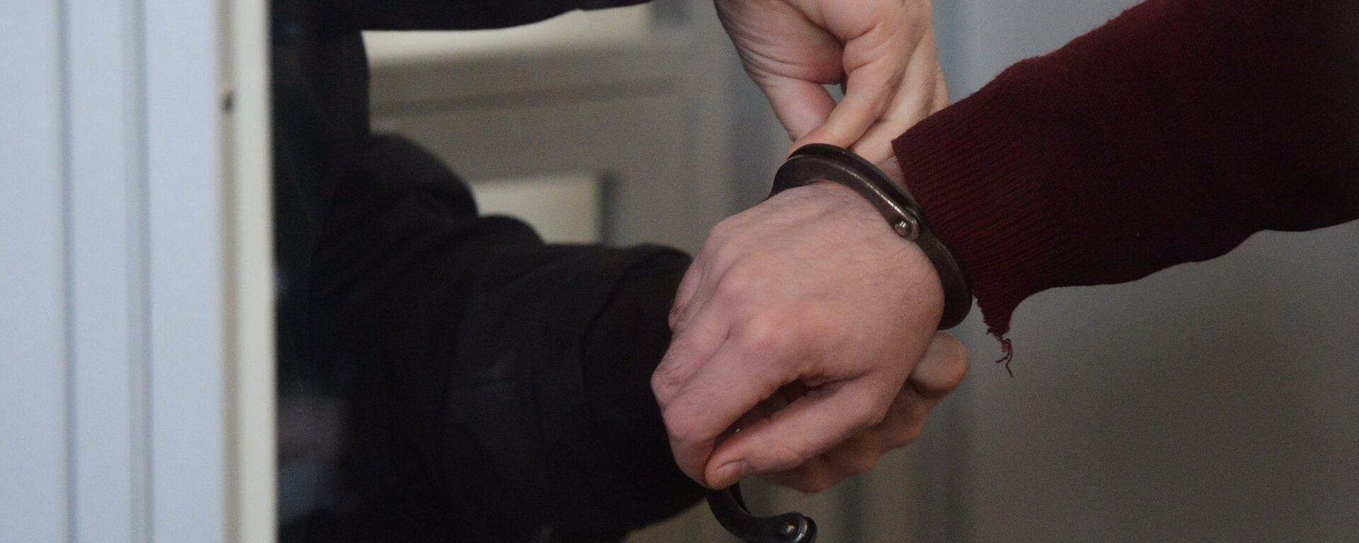Сотрудник правоохранительных органов снимает наручники, архивное фото - Sputnik Қазақстан, 1920, 06.02.2021