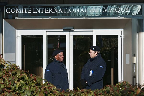 Сотрудники службы безопасности у входа в штаб-квартиру Международного олимпийского комитета в Лозанне Сотрудники службы безопасности у входа в штаб-квартиру Международного олимпийского комитета в Лозанне - Sputnik Казахстан