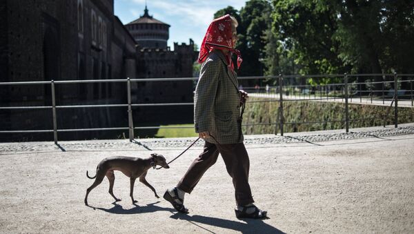 Местная жительница прогуливется с собакой у замка Сфорца в городе Милане - Sputnik Казахстан