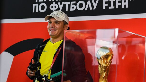 Мужчина фотографируется с кубком чемпионата мира по футболу, архивное фото - Sputnik Казахстан