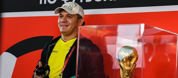 Мужчина фотографируется с кубком чемпионата мира по футболу, архивное фото - Sputnik Казахстан