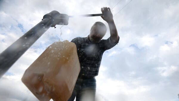 Мужчина набирает воду из колонки, архивное фото - Sputnik Казахстан