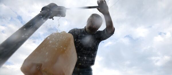 Мужчина набирает воду из колонки, архивное фото - Sputnik Казахстан