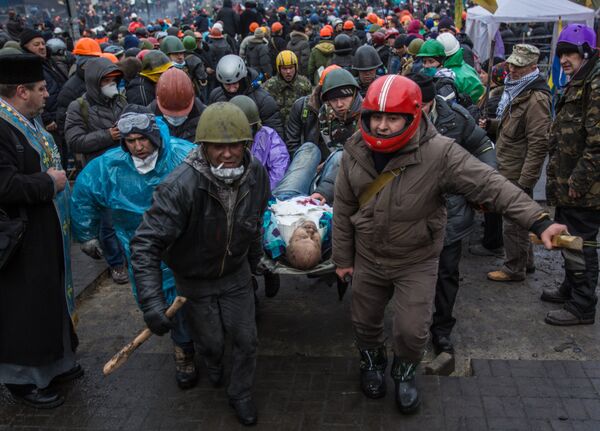 Сторонники оппозиции несут раненного во время столкновений с сотрудниками правопорядка в Киеве, архивное фото Сторонники оппозиции несут раненного во время столкновений с сотрудниками правопорядка в Киеве, архивное фото - Sputnik Казахстан