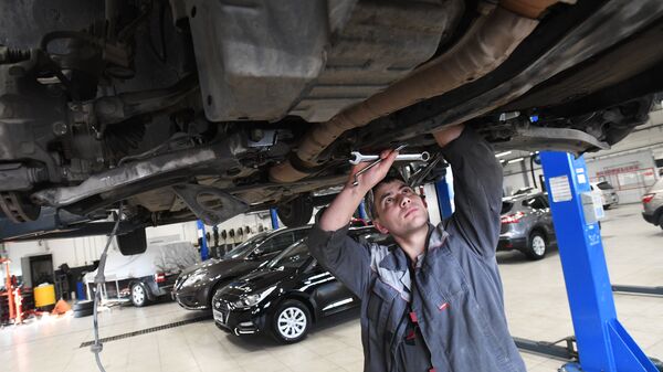 Сотрудник сервисного центра осматривает автомобиль - Sputnik Казахстан