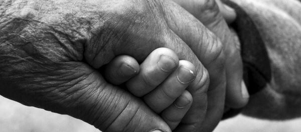 Пожилая женщина держит за руку ребенка, иллюстративное фото Пожилая женщина держит за руку ребенка, иллюстративное фото - Sputnik Казахстан