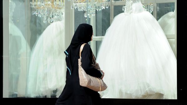 Женщина в мусульманской одежде проходит мимо витрин со свадебными платьями, архивное фото - Sputnik Казахстан