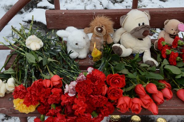 Цветы, свечи и мягкие игрушки возле здания торгового центра «Зимняя вишня» в Кемерово, где произошел пожар - Sputnik Казахстан