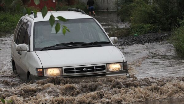 Автомобиль едет по улице во время паводка, архивное фото - Sputnik Казахстан