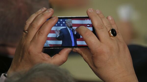 Человек фотографирует президента США Дональда Трампа - Sputnik Казахстан