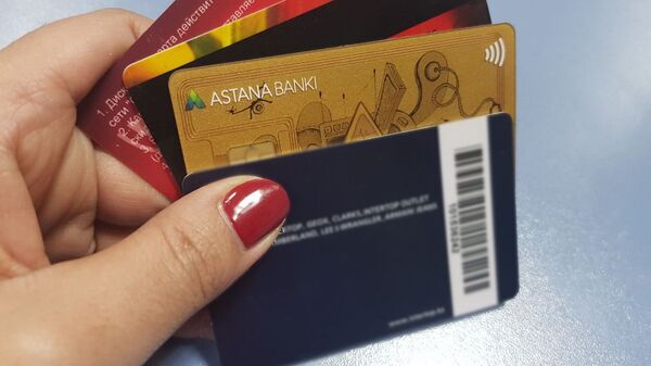 Банковские карточки в руке, архивное фото - Sputnik Казахстан
