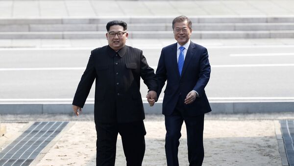 Лидер КНДР Ким Чен Ын и президент Южной Кореи Мун Чжэ Ин за руки пересекают границу в буферной зоне в Пханмунджоме - Sputnik Казахстан